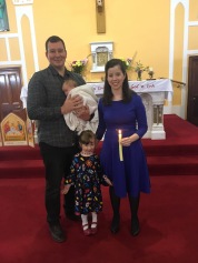 Clodagh Carmel Aylward on her baptism day with her parents Sharon and Wayne and sister, Keela.